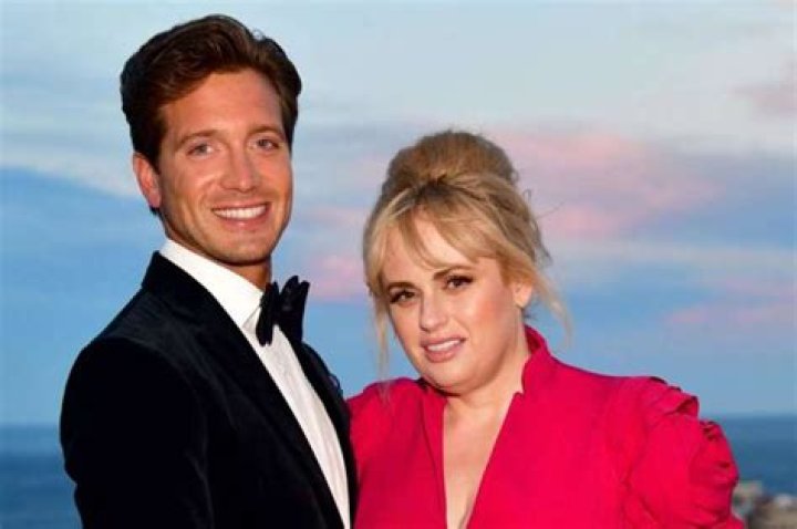 Rebel Wilson And Her BF Jacob Busch Pack The PDA In Cute Beach Video – Check Out Her Stunning Strapless Bathing Suit!